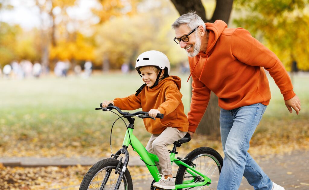 Grandfather pushing child on a bicycle. Keeping up with primary care can help keep you feeling your best.